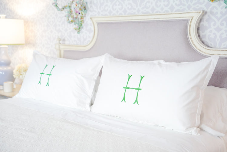 Caption: King Euro Shams with Lotus Monogram in Grass.